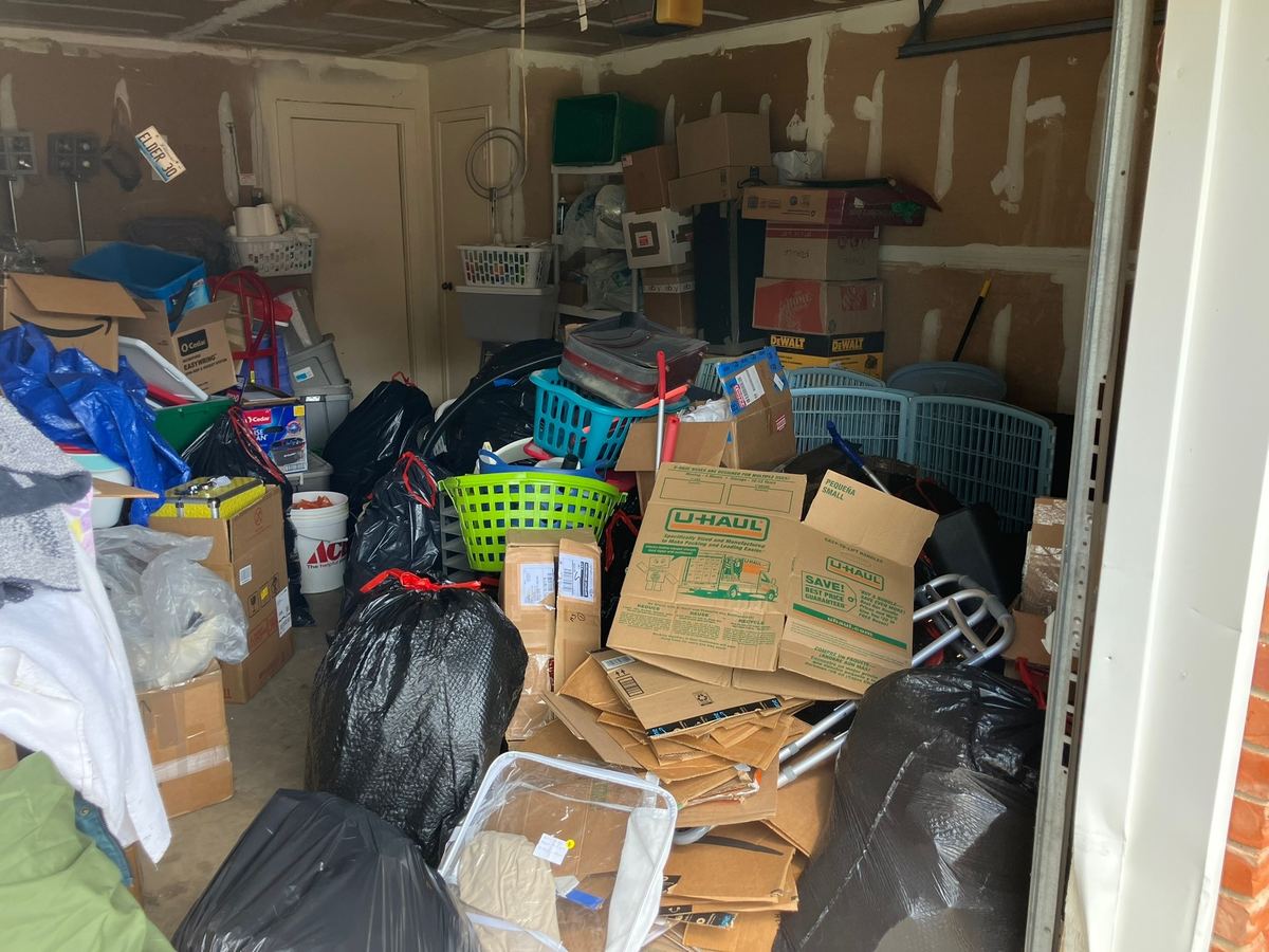 Garage packed with boxes, trash bags and laundry baskets