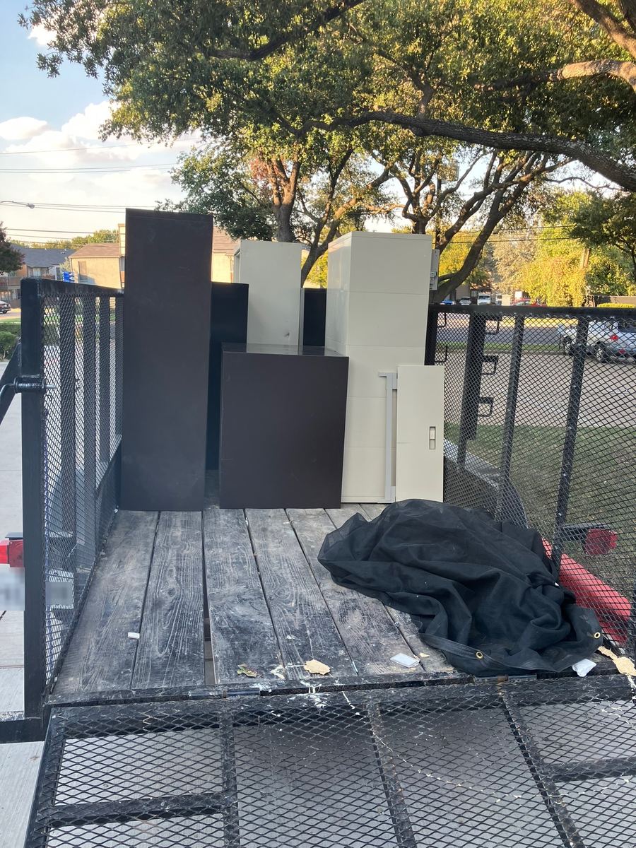 Tall file cabinets and storage cabinets standing on the deck of a hauling trailer